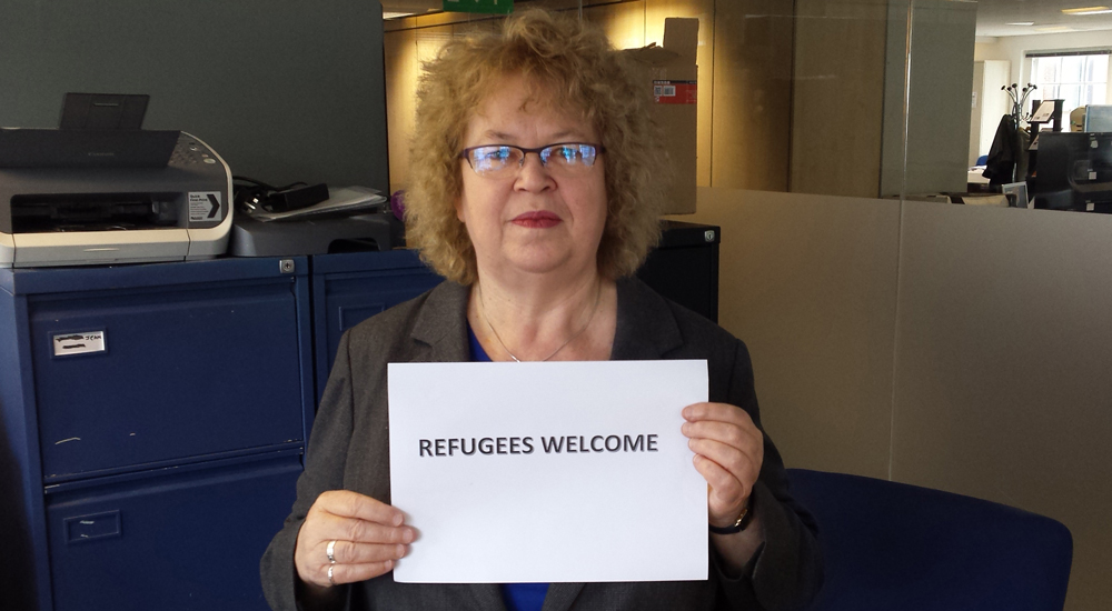 jean holding refugees welcome sign